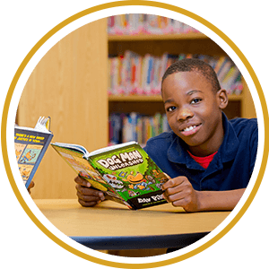 Boy smiling while holding a book
