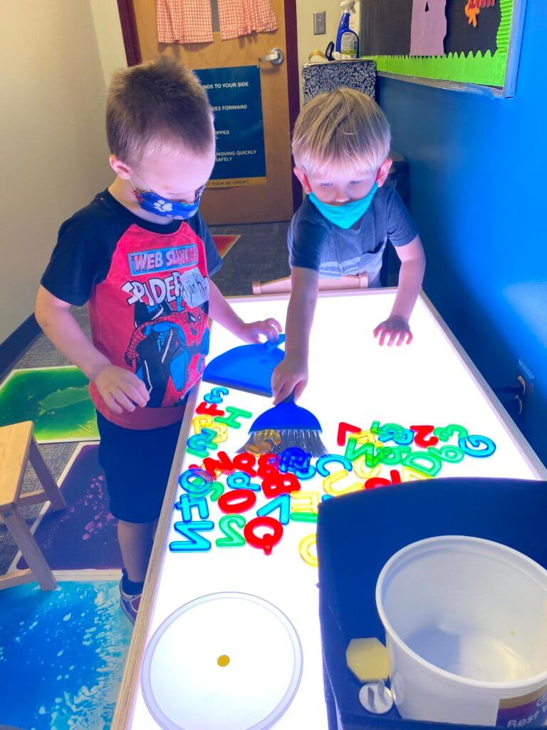 3-year olds forming words and playing with letters in the classroom