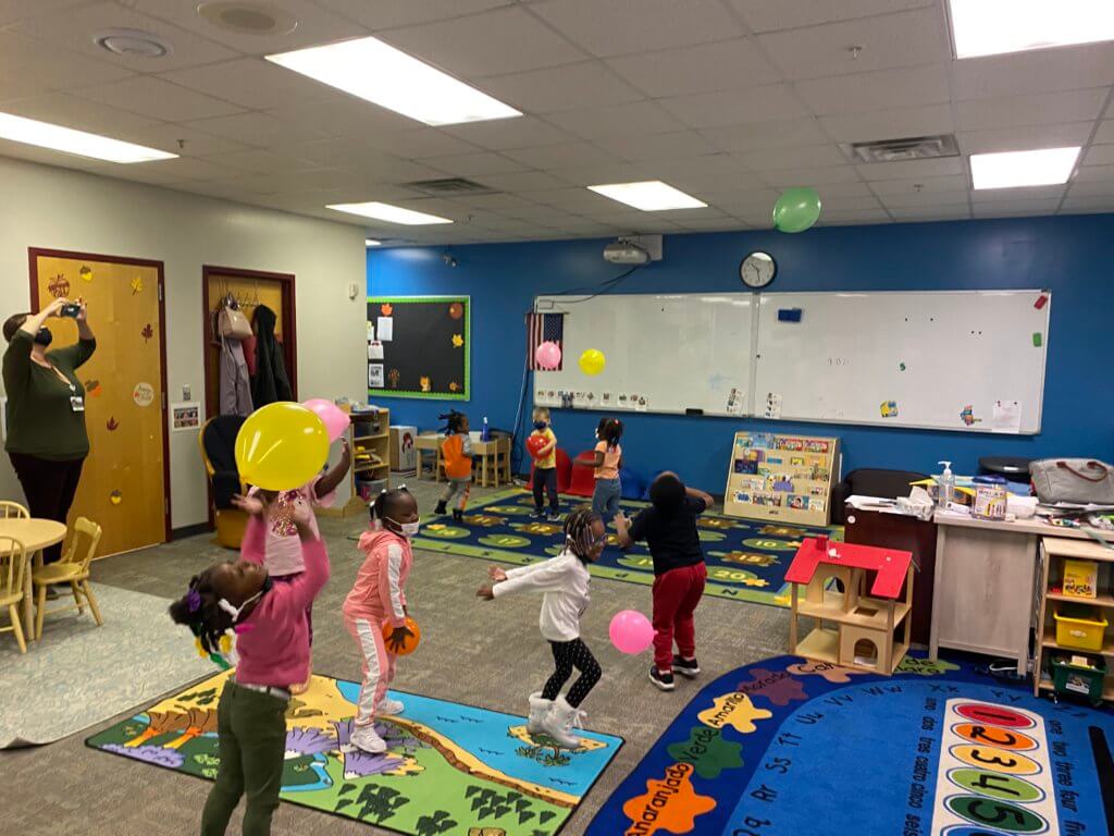 Children playing together in the classroom, playing with toys and socializing.