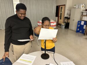 Two Benton Harbor Charter School Academy students work together in the classroom to prepare a Black History podcast as a school project.